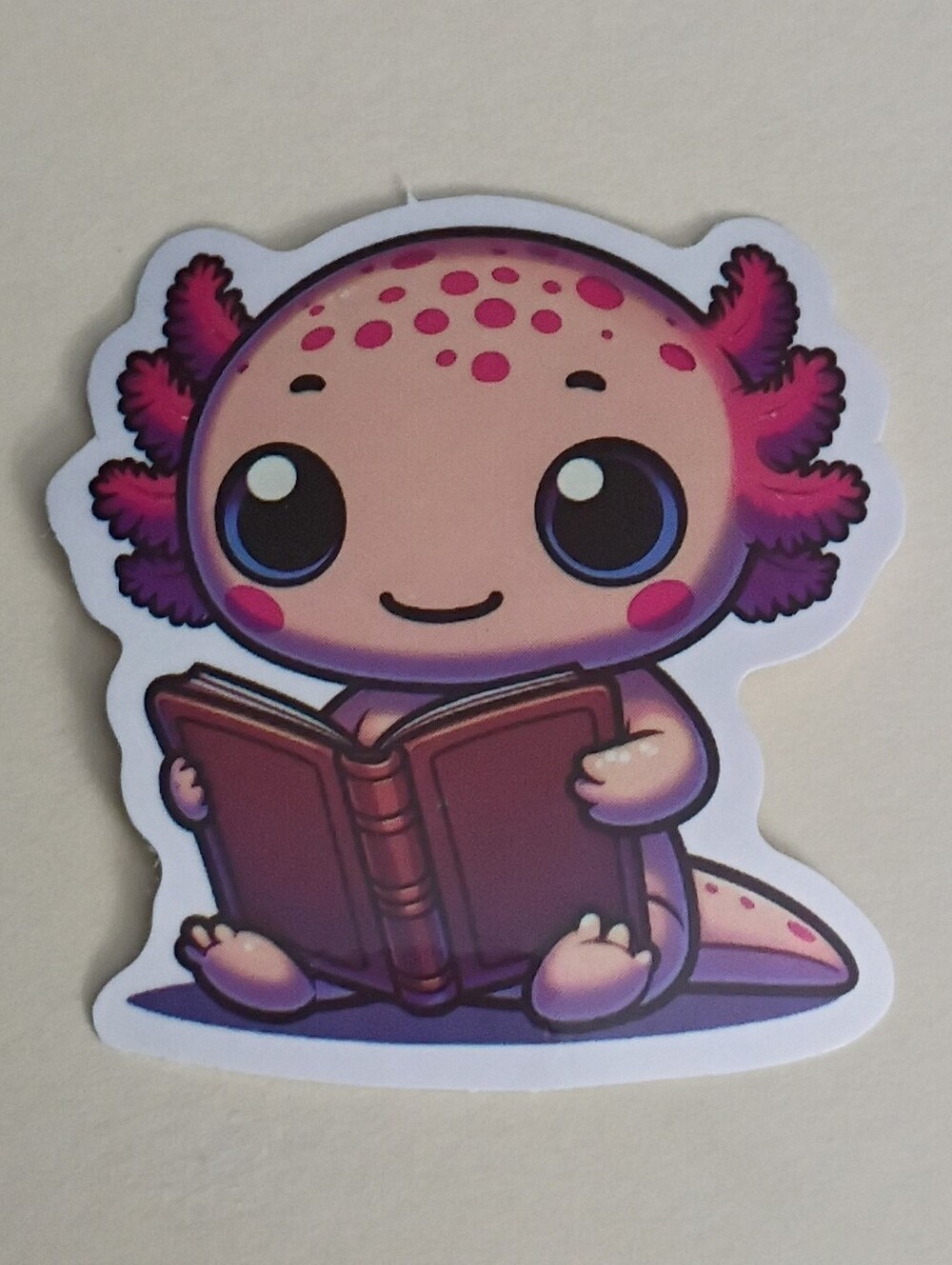 10/$10 Sticker - Axolotl Pink & Purple w/ Blue Eyes Reading Brown Book